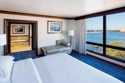 a hotel room with a bed and a large window at Sheraton Norfolk Waterside Hotel in Norfolk