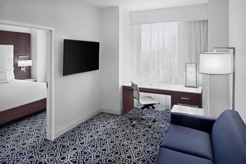 a hotel room with a bed and a desk and a chair at Residence Inn by Marriott Stamford Downtown in Stamford