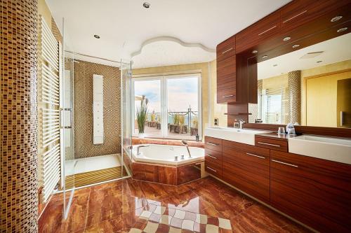 a large bathroom with a tub and a sink at Strandpalais Prinz von Preussen - Anbau vom Strandhotel Preussenhof in Zinnowitz