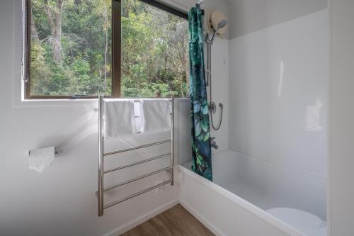 ein Bad mit einer Dusche und einem Fenster in der Unterkunft Bay View - Wainui Holiday Home in Akaroa