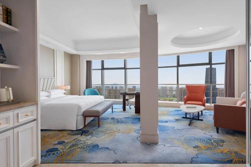 um quarto de hotel com uma cama, uma secretária e uma mesa em Sheraton Shaoxing Shangyu em Shaoxing
