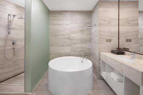 a bathroom with a white tub and a sink at Sheraton Shaoxing Shangyu in Shaoxing