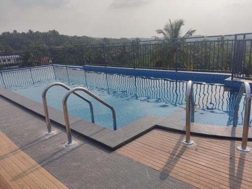 a swimming pool with stairs leading into the water at MANDARIN SKY in Kannur