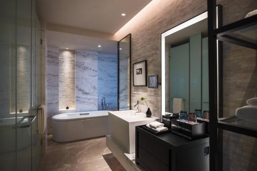 ein Badezimmer mit einer Badewanne, einem Waschbecken und einer Badewanne in der Unterkunft Renaissance Suzhou Taihu Lake Hotel in Suzhou