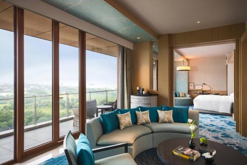 uma sala de estar com um sofá e uma grande janela em Renaissance Suzhou Taihu Lake Hotel em Suzhou