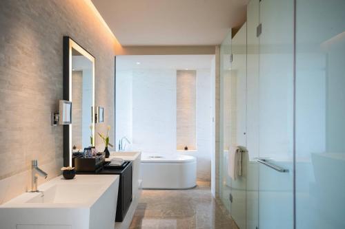 a bathroom with a tub and a sink and a mirror at Renaissance Suzhou Taihu Lake Hotel in Suzhou