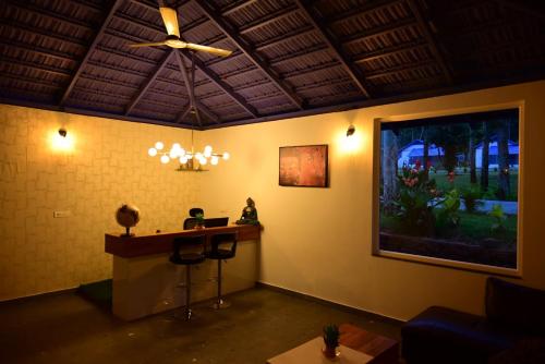 a room with a desk and a ceiling fan at Shree Kalya Resort- Chikmagalur in Chikmagalūr