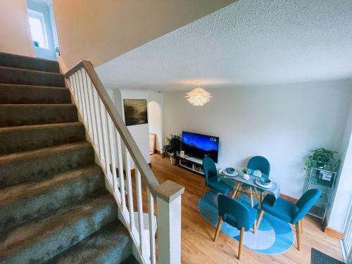 a living room with a table and blue chairs at Buckingham House - Charming 2-bedroom House with garden and parking in Buckingham