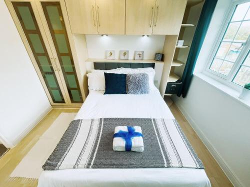 una piccola camera da letto con un letto con un oggetto blu sopra di Buckingham House - Charming 2-bedroom House with garden and parking a Buckingham