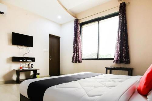 a bedroom with a bed and a large window at Meera Valley Resort in Udaipur