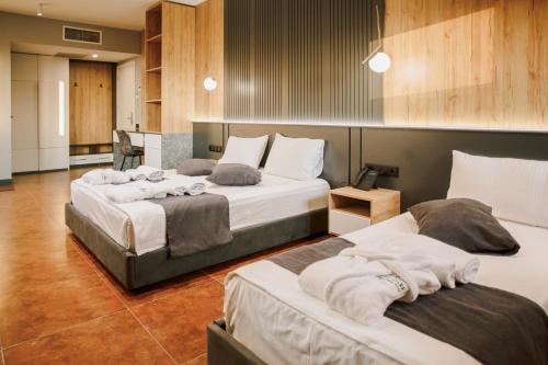 1 dormitorio con 3 camas y toallas. en Bel Mare Boutique Hotel en Batumi