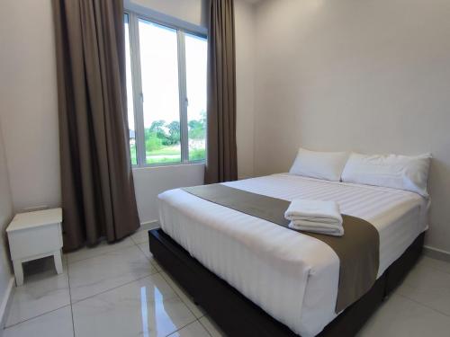 a bedroom with a large bed with a window at Lembah Saerah Resort in Kangar