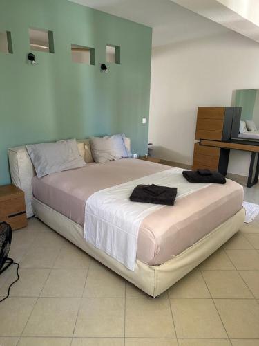 a bedroom with a large bed with two towels on it at Home 4U apt1, just 7km from airport in Markopoulo