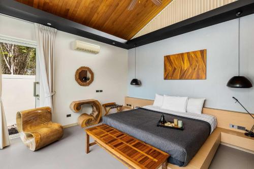 - une chambre avec un lit et une chaise dans l'établissement Villa Sunpao, à Layan Beach