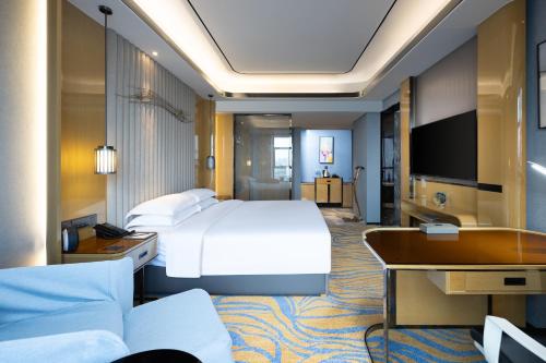 a hotel room with a bed and a desk at Courtyard by Marriott Nanchang in Nanchang