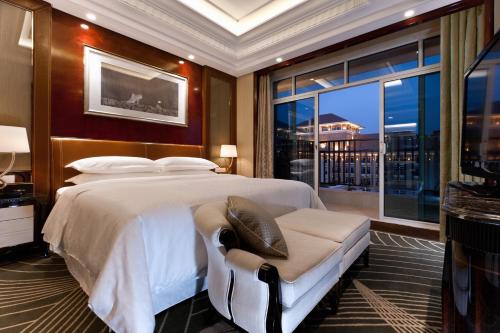 una camera con un grande letto e una grande finestra di Sheraton Changzhou Wujin Hotel a Changzhou