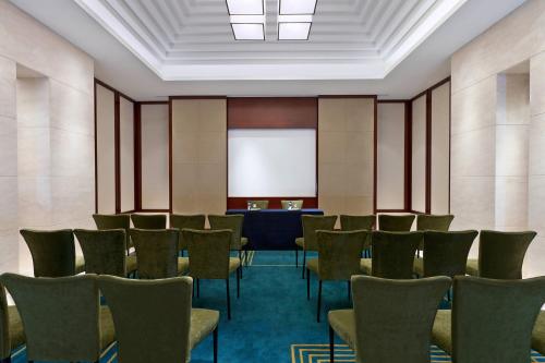 a conference room with chairs and a whiteboard at Sheraton Changzhou Wujin Hotel in Changzhou