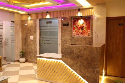 ein Badezimmer mit einer Dusche, einer Bank und einem Gemälde in der Unterkunft Hotel JMB in Jodhpur