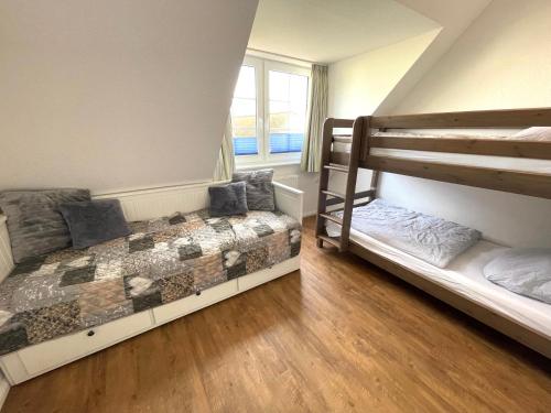a bedroom with two bunk beds and a window at Die Ostseeperle mit Pool 2 in Barendorf