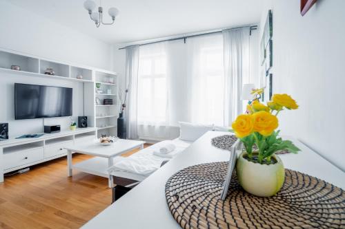 een witte woonkamer met een vaas met bloemen erin bij City Park Apartments - #16, #18 & D - Moderne Apartments & Suiten im Zentrum in Leipzig