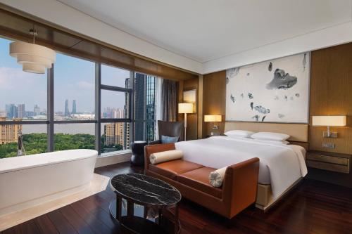 um quarto com uma cama grande e uma banheira e uma banheira em Courtyard by Marriott Hangzhou Qianjiang em Hangzhou