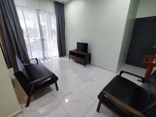 a living room with a chair and a tv in it at Lembah Saerah Resort in Kangar