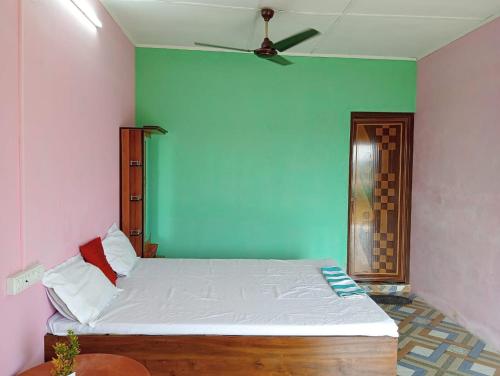 - une chambre dotée d'un lit avec un mur vert dans l'établissement Poddar Retreat Managed by Wheels And Wings, à Dām Dim