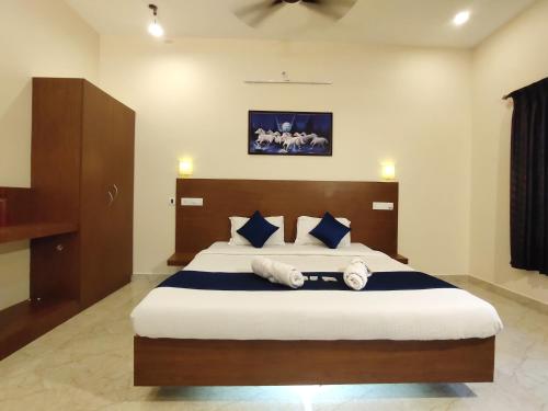 - une chambre dotée d'un grand lit avec des oreillers bleus et blancs dans l'établissement PV Resort - Auro Beach, à Auroville