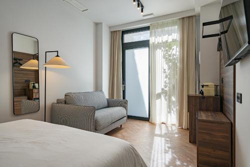 1 dormitorio con 1 cama, 1 silla y 1 ventana en Style Suites by Olala Homes, en Madrid