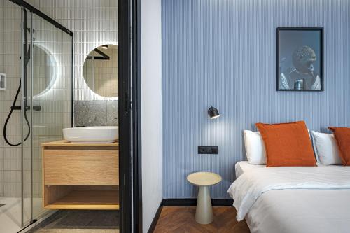 1 dormitorio con 1 cama y baño con lavamanos en Style Suites by Olala Homes, en Madrid