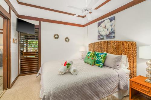 a bedroom with a bed with a teddy bear on it at KP41 1Br Poipu Condo with AC, Steps to the Beach in Koloa
