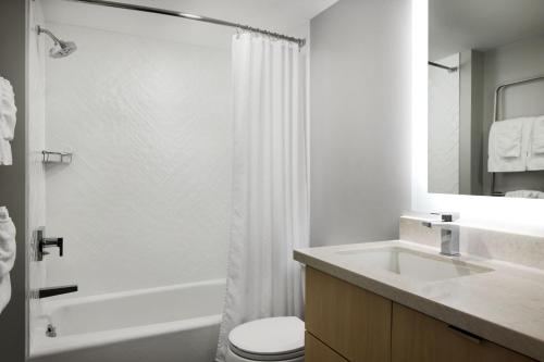 a bathroom with a toilet and a sink and a shower at TownePlace Suites Dulles Airport in Sterling
