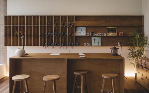 a wooden bar with stools in a room at Uon in Gyeongju