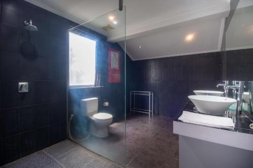 a bathroom with a toilet and a sink and a shower at Aleesha Villas and Suites in Sanur