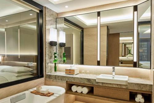 a bathroom with a sink and a large mirror at Hangzhou Marriott Hotel Qianjiang in Hangzhou
