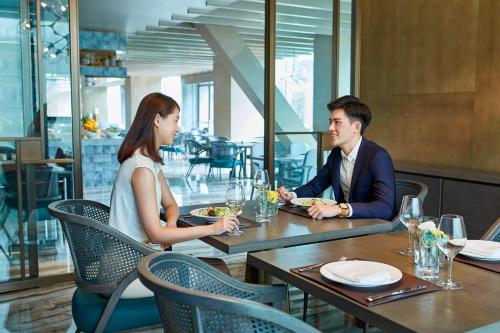 a man and woman sitting at a table in a restaurant at Hangzhou Marriott Hotel Qianjiang in Hangzhou