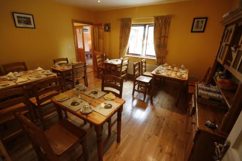 einen Blick über ein Esszimmer mit Tischen und Stühlen in der Unterkunft Macreddin Rock Bed & Breakfast in Aughrim