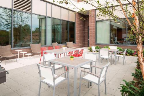 a patio with tables and chairs in front of a building at Residence Inn by Marriott Boston Watertown in Watertown