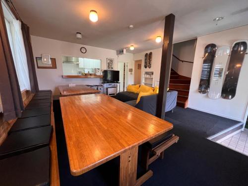 Una sala de estar con una mesa de madera y un sofá. en TaoTechHOUSE, en Hakuba