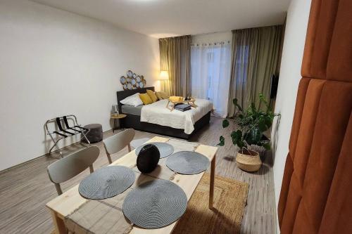 a living room with a table and chairs and a bed at Apartmán Sky s balkonem in Beroun