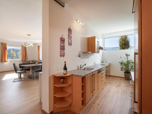 a kitchen with a sink and a table with a bottle of wine at 4 Elements in Hopfgarten im Brixental