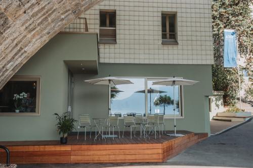 eine Terrasse mit Tischen, Stühlen und Sonnenschirmen in der Unterkunft Montreux Youth Hostel in Montreux