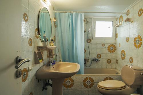a bathroom with a sink and a toilet and a shower at Vrilissia cozy apartment in Athens