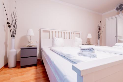 a white bedroom with a large white bed at City Park Apartments - #11-12 - Apartments mit Ambiente am Park in Leipzig