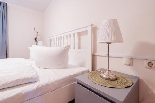 ein Schlafzimmer mit einem Bett und einer Lampe auf einem Nachttisch in der Unterkunft City Park Apartments - #11-12 - Apartments mit Ambiente am Park in Leipzig
