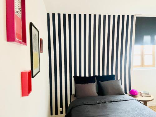 a bedroom with a bed and a striped wall at Appart 2 chambres HYPERCENTRE de Berck-Plage - WIFI in Berck-sur-Mer