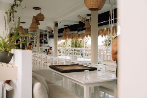 un restaurante con mesas blancas y una barra en The Surfer Sri Lanka - Surf Camp, en Weligama