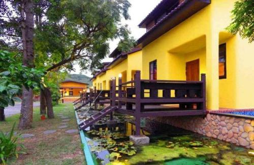 a yellow house with a pond in front of it at 墾丁牧場Villa Kenting Pasture - Villa B&B in Kenting