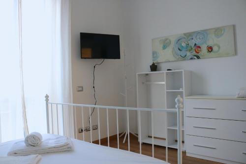 um quarto com uma cama, uma cómoda e uma televisão em Lovely Navigli Studio with balcony - Via Carlo torre em Milão