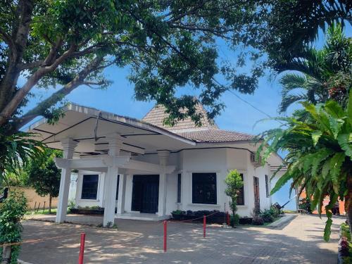a white building with trees in front of it at Residence Tanjung Pakuan in Bogor